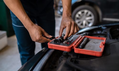 Mechanic selecting an optical tool for work Cropped photo of a car technician taking out a magnifying glass from the open toolbox
