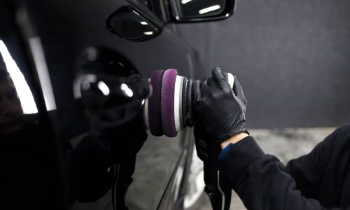 worker-detailing-center-polishes-car-body worker-detailing-center-polishes-car-body